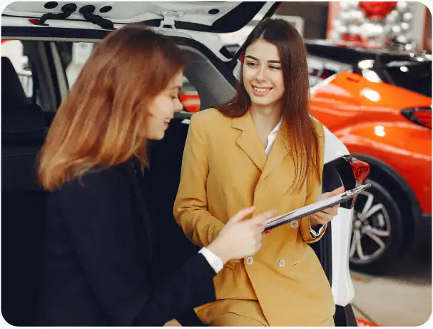 Female car sales rep talking to female customer about Justdriveaway drive away car insurance options